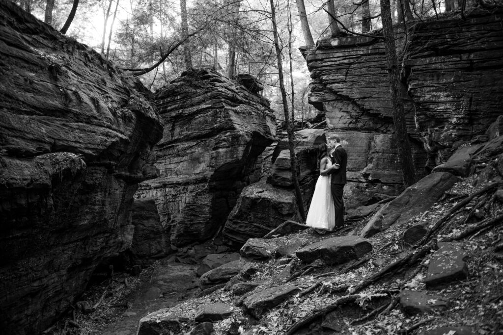 bride and groom in a white dress and black tux, kissing in Cuyahoga Valley National Park on their wedding day. Photo taken by Cleveland wedding photographer Aaron Aldhizer