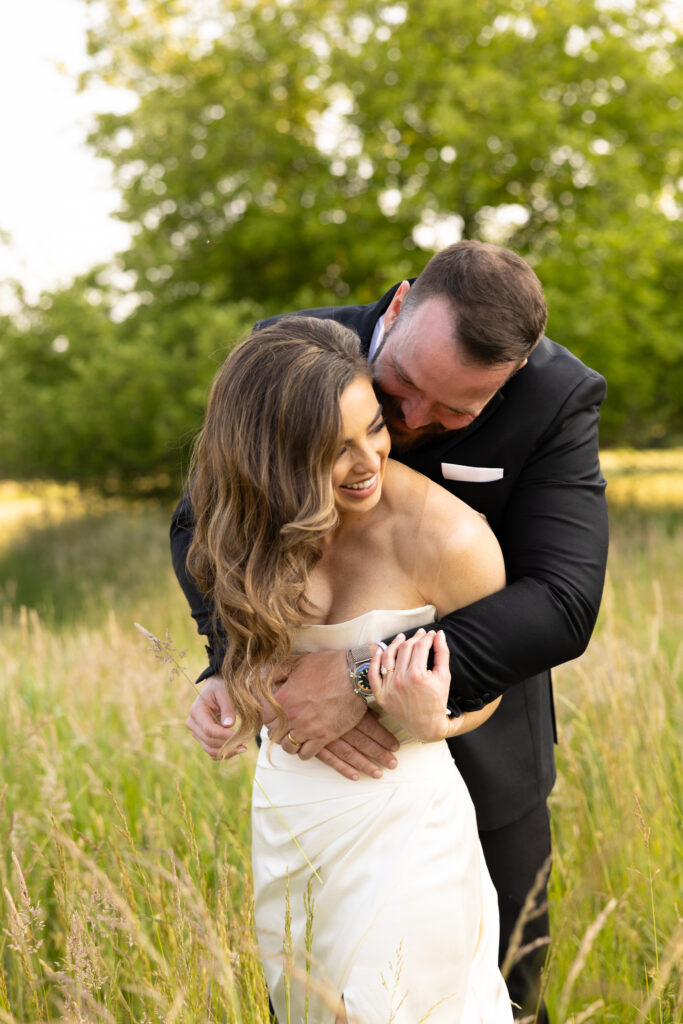a bride and groom embrace one another during their couples portraits on their wedding day in Bracesville, Ohio. A true love story. Friends of more than 20 years before dating. And now finally happily married! Photo taken by Cleveland Wedding Photographer Aaron Aldhizer