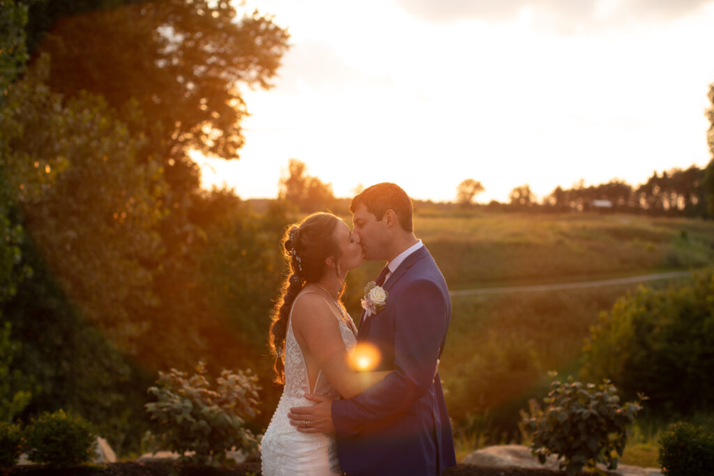 Bride and groom kissing each other and at sunset on their wedding day at Blue Heron Brewery & Event Center. Photo taken by Cleveland Wedding photographer Aaron Aldhizer