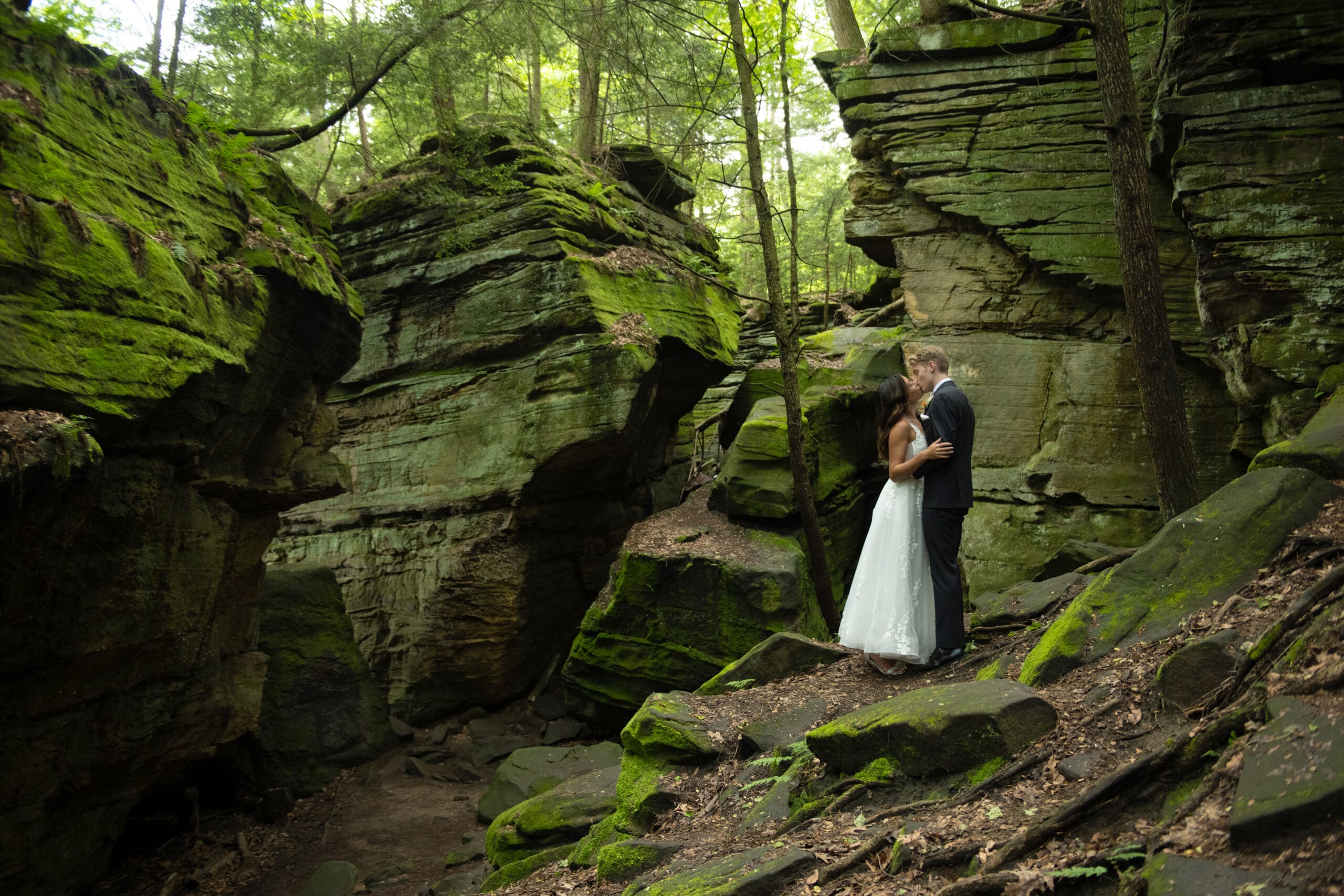 Bride and groom embrace and share a kiss while celebrating their wedding day at Cuyahoga Valley National Park. Photographed by Aaron Aldhizer